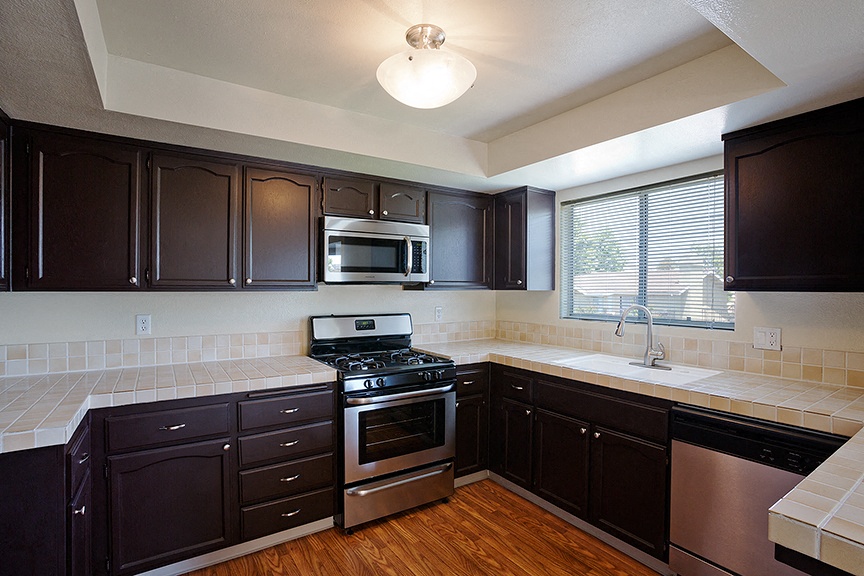 a kitchen with black cabinets and stainless steel appliances